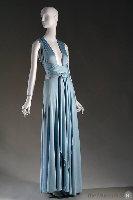 Light blue floor length halter dress with deep open V-neckline and criss-crossing ties at waist