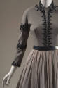 Detail view of grey set showing black sequin and bead trim on collar, on either side of front c…