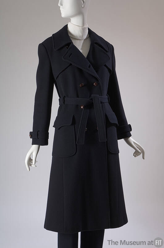 Navy blue double breasted trench coat with two flapped patch pockets, tie belt and matching pan…