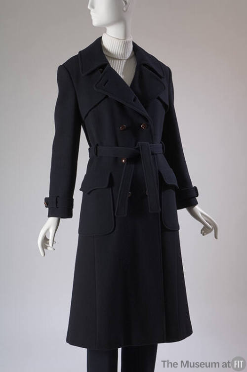 Navy blue double breasted trench coat with two flapped patch pockets, tie belt and matching pan…