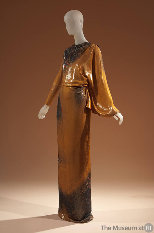 Shimmery orange and black abstract print floor length evening dress with one fitted sleeve and …