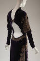 Back of purple long sleeved dress with emroidered gold details, cut away back