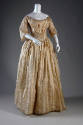 Ivory floor length dress with vertical patterned stripes, wide open neck, V-shaped pleating at …
