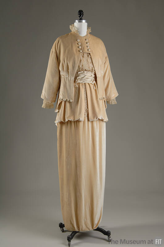 Beige velvet eight button cutaway jacket, lace top, matching floor length draped skirt with dou…