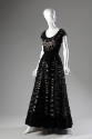 Black floor length evening gown with large cut-outs inset with black lace, cap sleeves and flar…