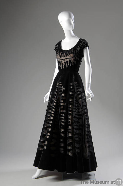 Black floor length evening gown with large cut-outs inset with black lace, cap sleeves and flar…