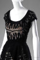 Detail view of black evening gown bodice showing lace inset cut-outs across bust and shoulders