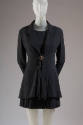 Black long sleeve jacket with peplum front and single brass button, matching pleated mini skirt