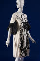 Off-white knee length dress with black abstract motif down entire front and ¾ length bell sleev…