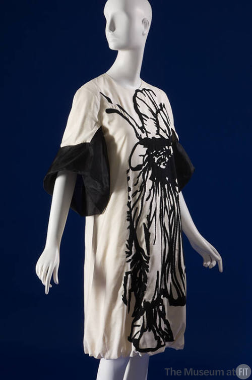 Off-white knee length dress with black abstract motif down entire front and ¾ length bell sleev…