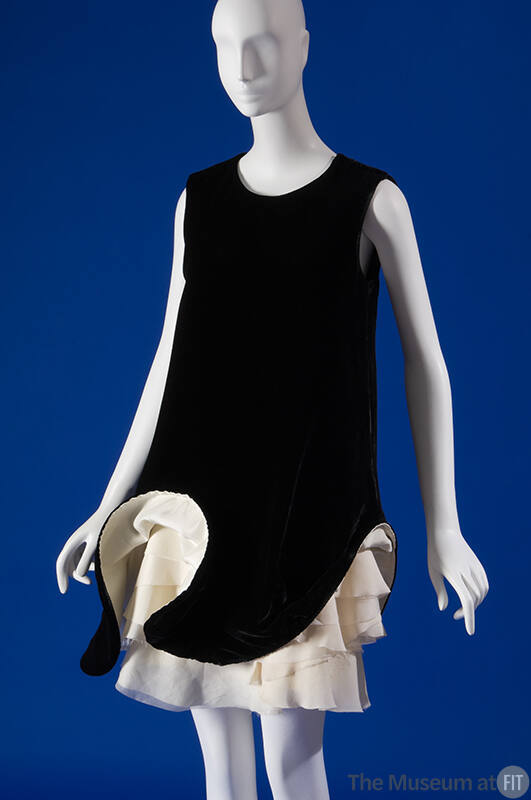 Black sleeveless above the knee shift dress with sculpted hem revealing tiered ivory underskirt