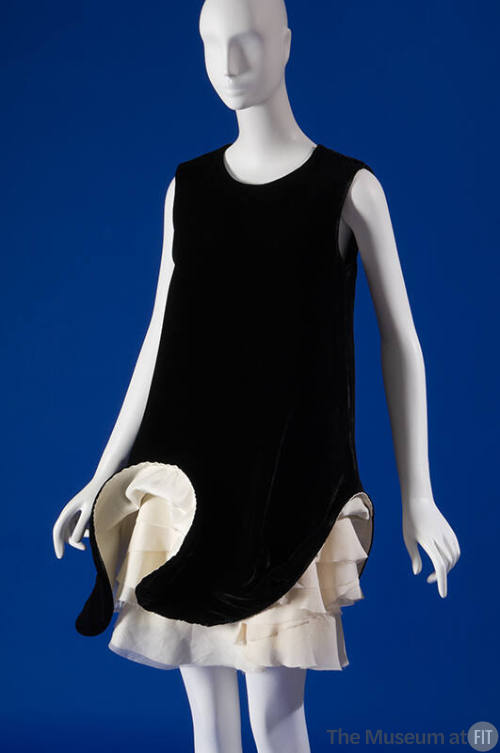 Black sleeveless above the knee shift dress with sculpted hem revealing tiered ivory underskirt