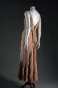 Back view of light brown evening dress with deep V-back, fabric panels down center back meeting…