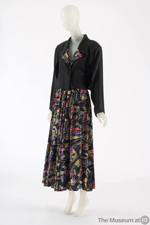 Black long sleeve jacket with multi-color lapels and ankle-length skirt with allover geometric …
