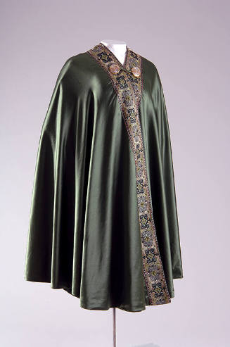 Green silk hip length cape with multicolor ribbon trim and single frog neck closure