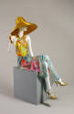 Gold straw sun hat, yellow floral bathing suit, blue multicolor sarong, gold strappy high heel …