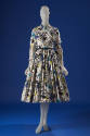 White long sleeve button front shirt dress printed with blue, black and green parade design, fu…