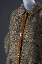Close up of brown shag tweed poncho with collar, tan suede front band, and buttons
