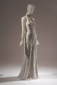 Off-white halter style evening sheath encrusted with tiny white sequins; mock turtleneck band