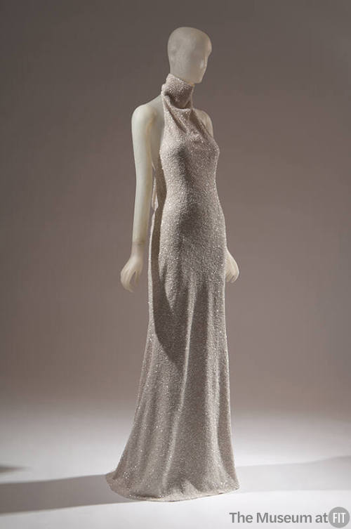 Off-white halter style evening sheath encrusted with tiny white sequins; mock turtleneck band