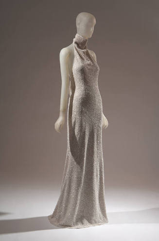 Off-white halter style evening sheath encrusted with tiny white sequins; mock turtleneck band