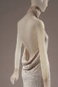 Off white backless halter style evening sheath with tiny white sequin; mock turtleneck band; dr…