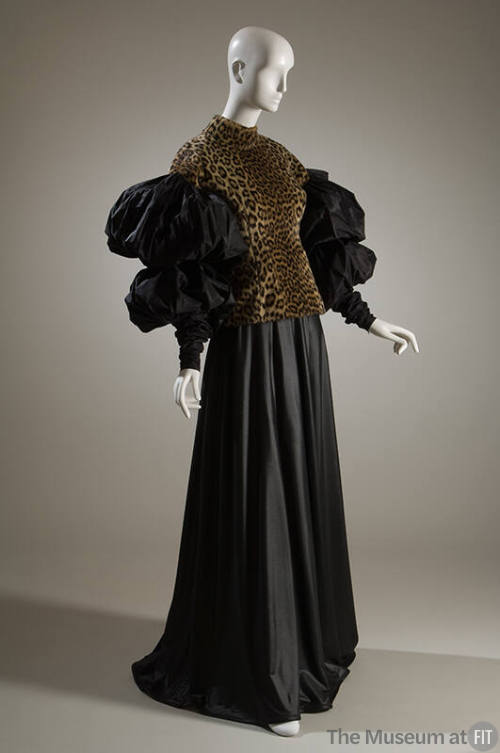 Leopard print top with band collar, black sleeves of two oversize puffs and fitted forearm with…
