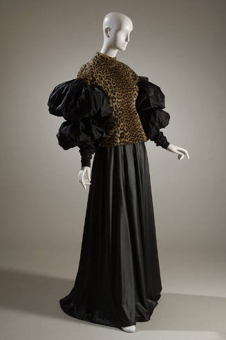 Leopard print top with band collar, black sleeves of two oversize puffs and fitted forearm with…