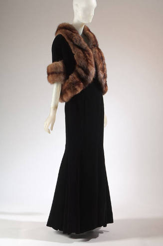 Black floor length evening dress and matching jacket with elbow length sleeves and brown fur tr…