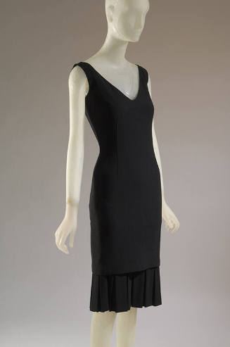 Black V-neck sheath dress with box pleated flounce at hem