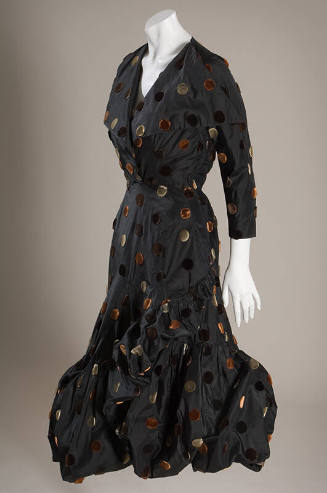 Black cocktail dress with large grey, tan and brown velvet dots, 7/8 length sleeves and asymmet…