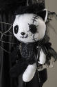 Detail view of doll carried by the mannequin of a black and white stylized cartoon cat with a s…