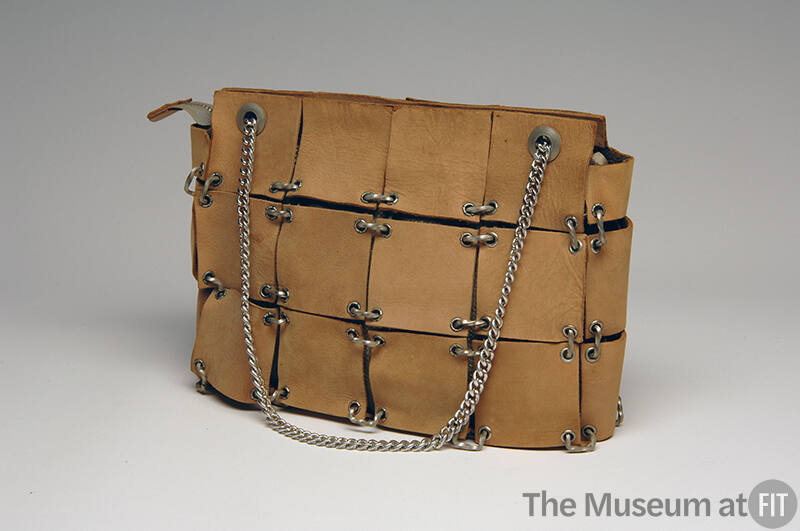 Purse comprising of tan suede squares with white metal eyelets and silver chain straps
