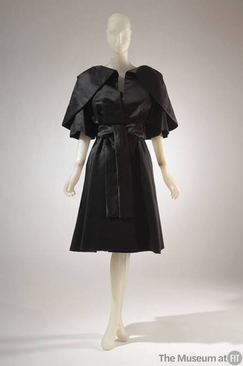 Black cape with large pleated cape collar and matching sleeveless dress