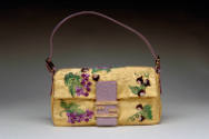 Gold bag embroidered with grapes and leaves, purple snakeskin closure with goldtone logo, purpl…