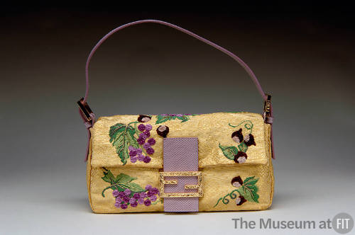 Gold bag embroidered with grapes and leaves, purple snakeskin closure with goldtone logo, purpl…