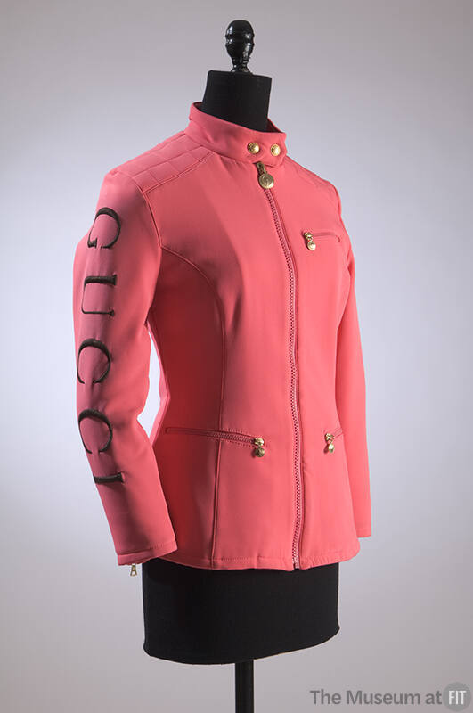 Hot pink fitted ski jacket with black Gucci logo embroidered down left sleeve, stand band colla…