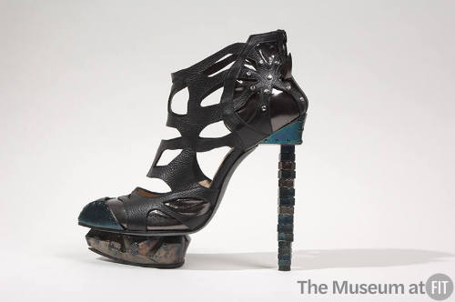 Black leather cut-out ankle boot with blue and bronze metal toe cap, platform sole and stacked …