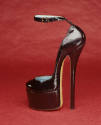 Side view of black patent leather platform ankle strap shoe with high spike heel