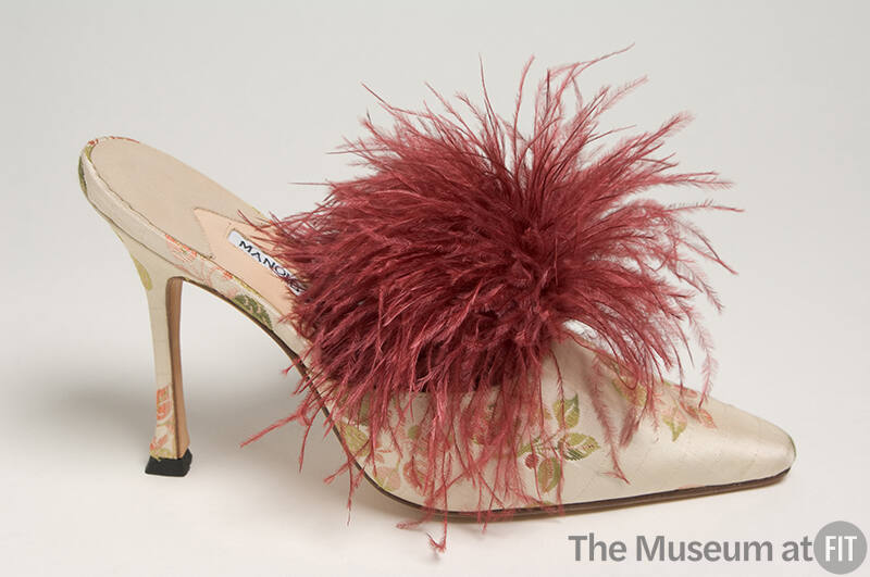 Off-white high heel mule with red and green berry brocade design and tuft of dark red feathers …