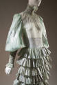 Detail of pale green with silver abstract design silk evening dress, high neck, long puff sleev…