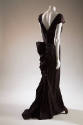 Back view of bronze and black taffeta brocaded short sleeve V-neck floor length dress with bust…