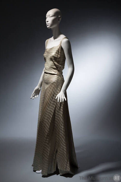 Light blue floor length evening dress with gold horizontal sawtooth stripes, asymmetrical bodic…