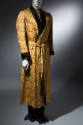 Man’s gold silk damask dressing gown with black shawl collar and cuffs and tie waist with black…