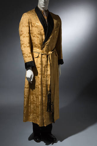 Man’s gold silk damask dressing gown with black shawl collar and cuffs and tie waist with black…