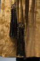 Detail view of man’s gold dressing gown showing damask of repeating camel and landscape scene a…