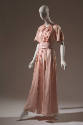 Pink ankle length afternoon dress, tie collar, short bell sleeves, and matching sash at waist