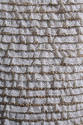 Detail view of silver evening dress showing rows of white lace edged with clear rhinestones and…