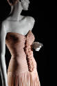 Detail view of pink dress showing molded bodice with tucks and stitching to create ruffle effec…