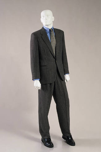 Man’s brown, tan and grey tweed single breasted suit dressed with blue oxford shirt, grey tie a…